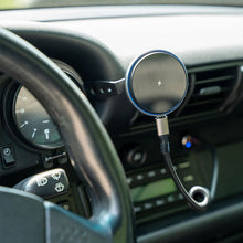 Wireless charging puck mounted on Porsche 911 gauge phone holder