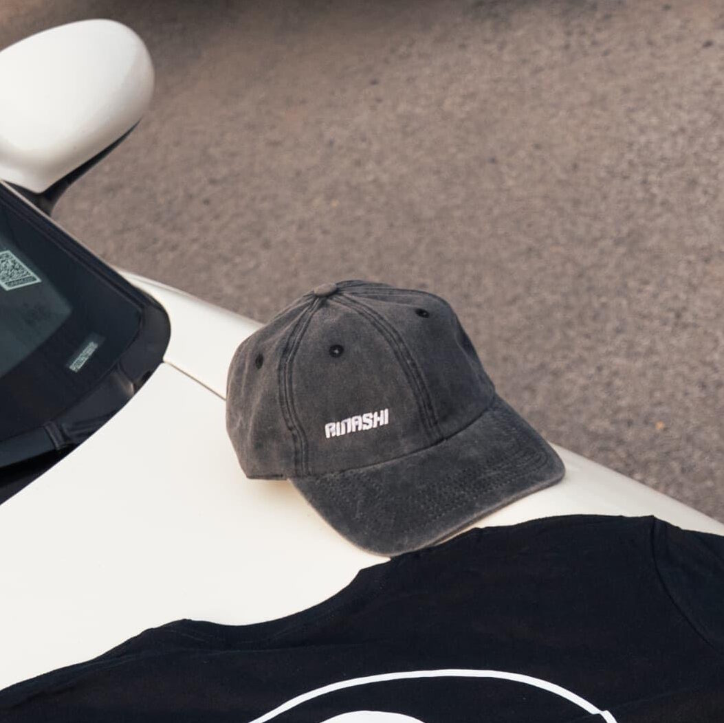 Gray Rinashi dad cap displayed with black shirt on car hood